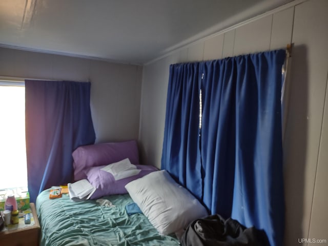 bedroom featuring ornamental molding and multiple windows