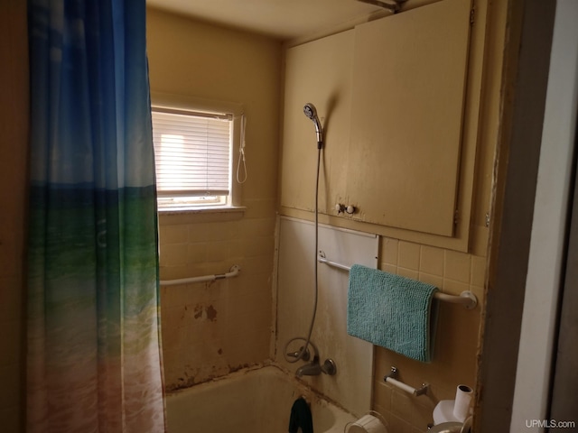 bathroom with shower / bath combination with curtain, toilet, and tile walls