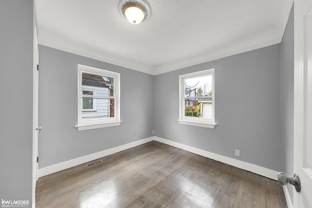 unfurnished room featuring dark hardwood / wood-style floors and ornamental molding