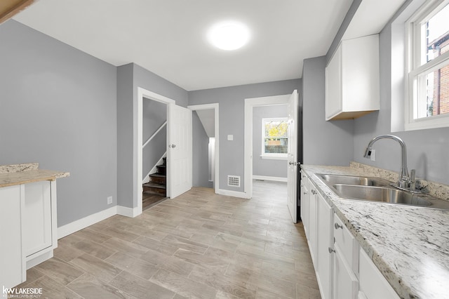 kitchen with white cabinetry and sink