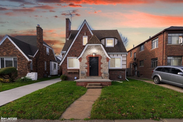 tudor home featuring a lawn