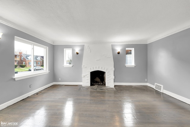 unfurnished living room featuring a fireplace, a textured ceiling, dark hardwood / wood-style floors, and crown molding