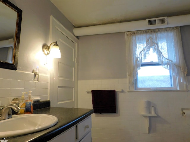 bathroom with vanity and tile walls