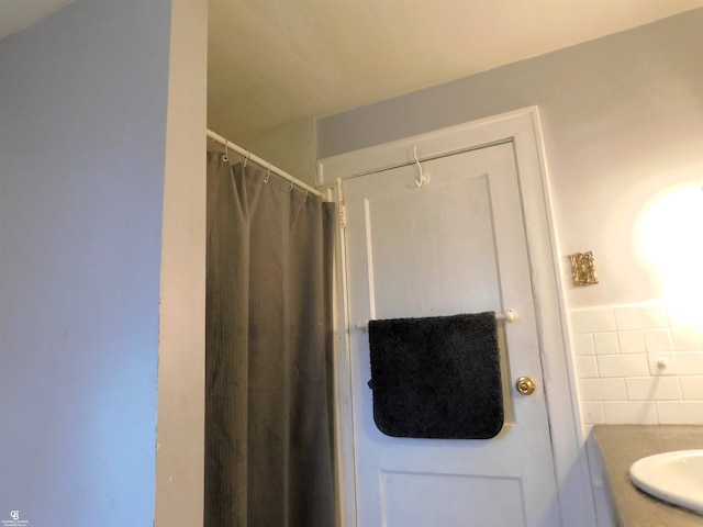 bathroom featuring vanity and tile walls