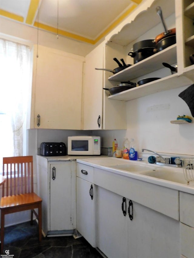 kitchen featuring white cabinets and sink