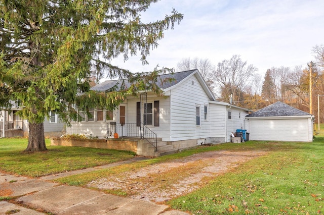 view of front of house featuring a garage, an outbuilding, and a front yard