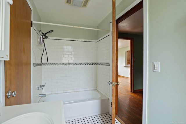 bathroom featuring wood-type flooring and tiled shower / bath combo