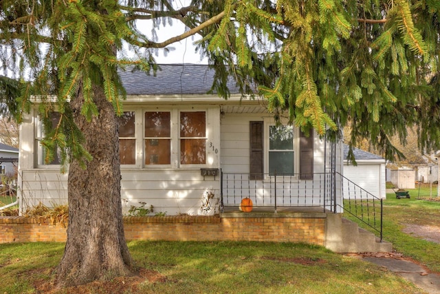 310 S Main St, Vassar, MI 48768 - view of front of house with roof with shingles, a front lawn, and a garage