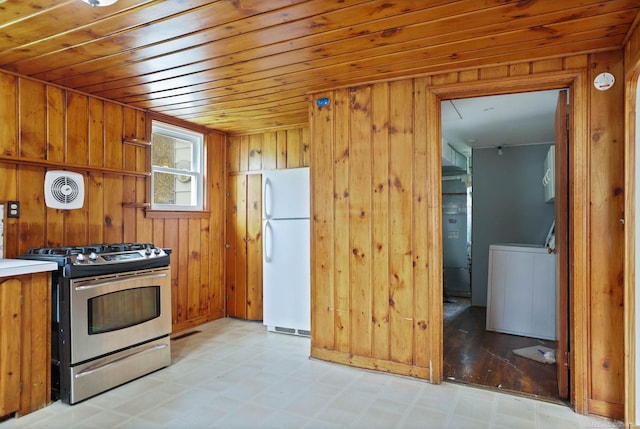 310 S Main St, Vassar, MI 48768 - kitchen with stainless steel gas range, freestanding refrigerator, light flooring, washer / dryer, and brown cabinetry