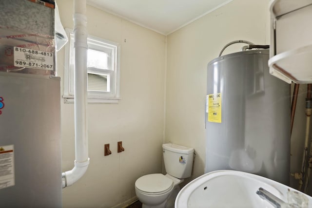 bathroom featuring toilet, electric water heater, and ornamental molding