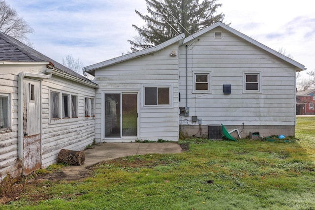 back of house with a lawn and central AC unit