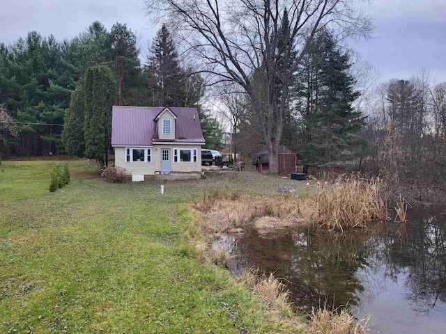 back of house featuring a lawn and a water view