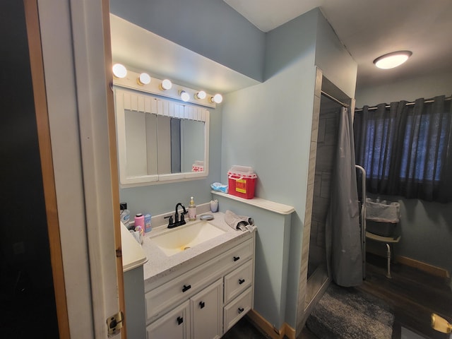 bathroom featuring hardwood / wood-style flooring, vanity, and curtained shower