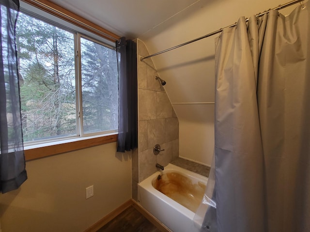 bathroom featuring hardwood / wood-style flooring and shower / bath combo with shower curtain