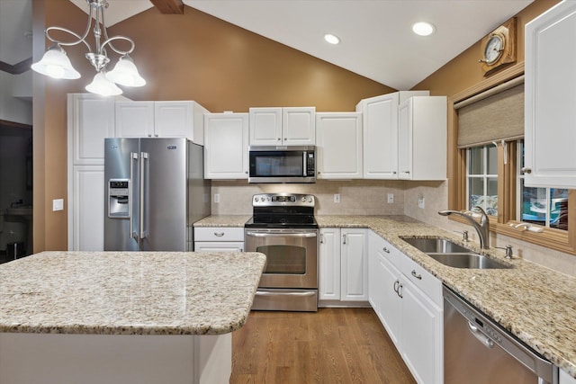 kitchen with white cabinetry, sink, stainless steel appliances, backsplash, and decorative light fixtures