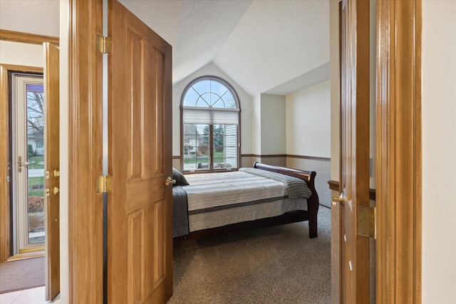 bedroom featuring light colored carpet and vaulted ceiling