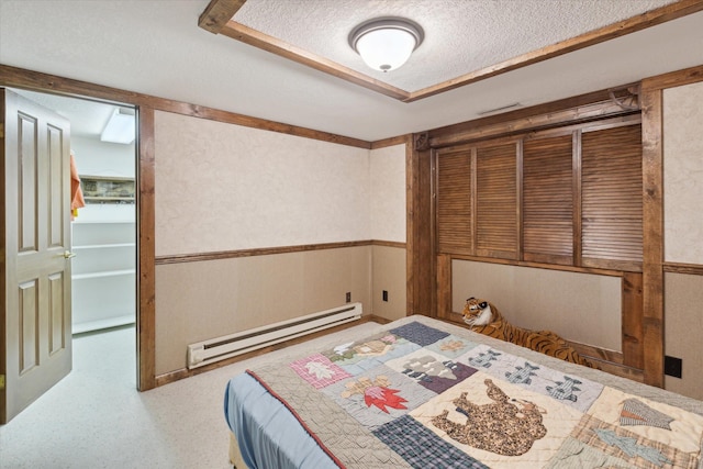 bedroom with baseboard heating and a textured ceiling