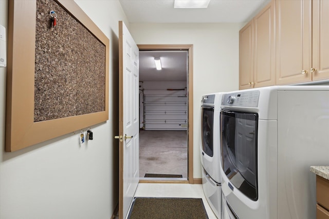 laundry area with washing machine and clothes dryer and cabinets