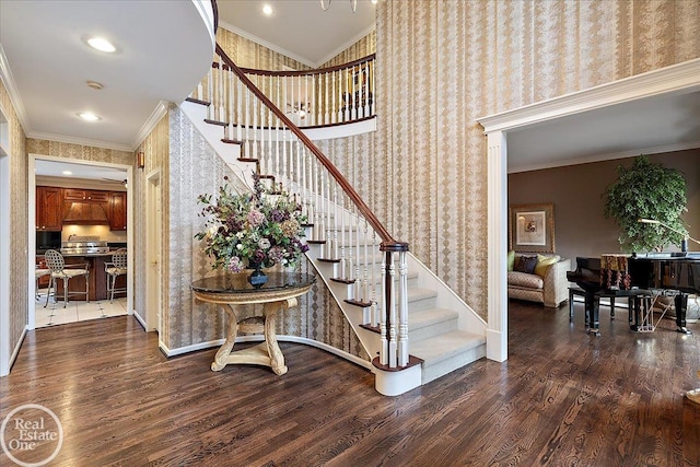 staircase featuring wallpapered walls, baseboards, wood finished floors, crown molding, and recessed lighting