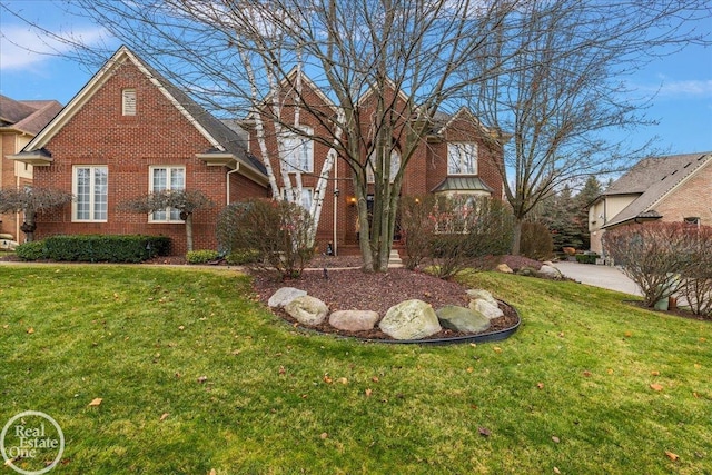 view of front facade featuring brick siding and a front yard