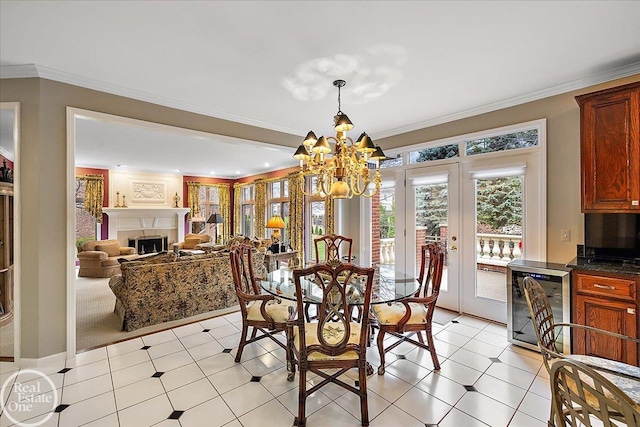 dining area featuring beverage cooler, crown molding, french doors, a fireplace, and a chandelier