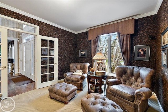 sitting room with french doors, crown molding, and wallpapered walls