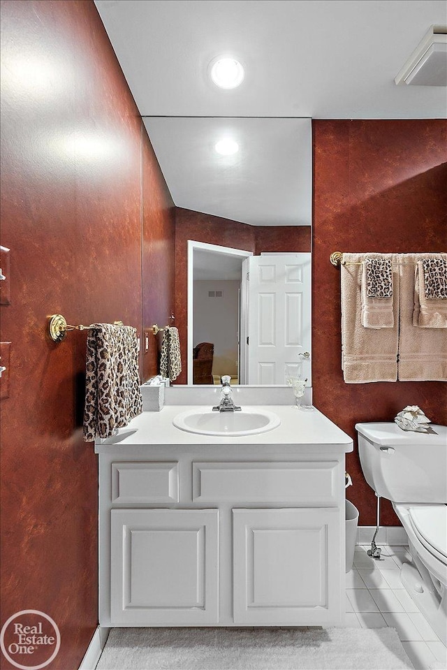 half bathroom with toilet, vanity, visible vents, and tile patterned floors