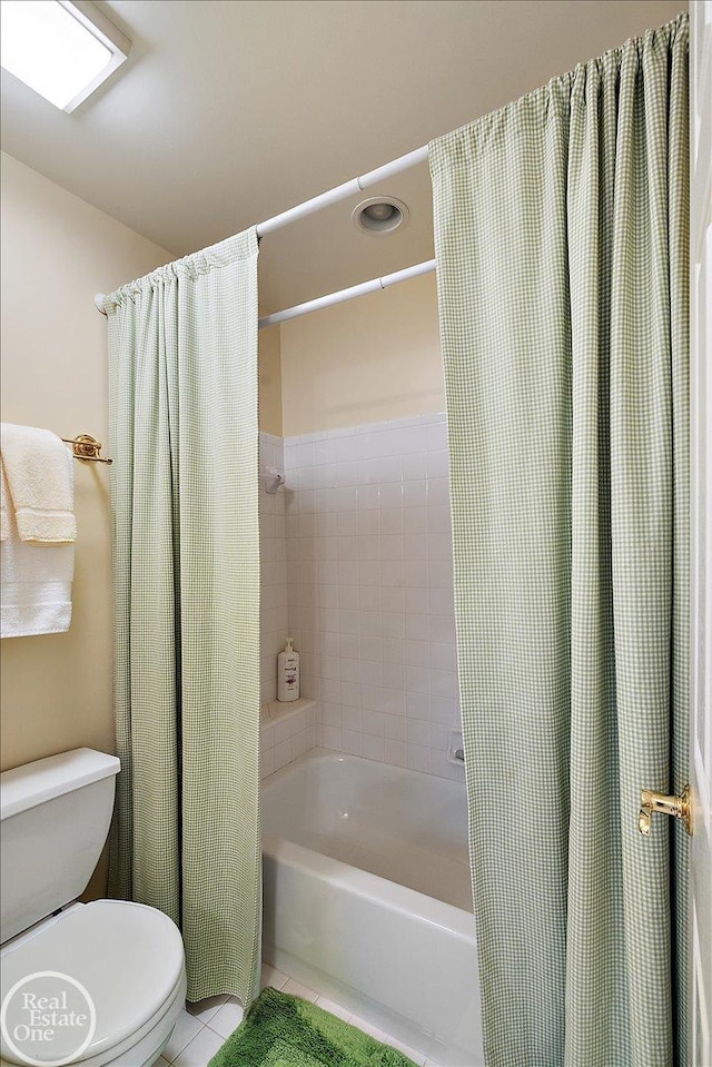 full bathroom featuring tile patterned flooring, toilet, and shower / bath combo