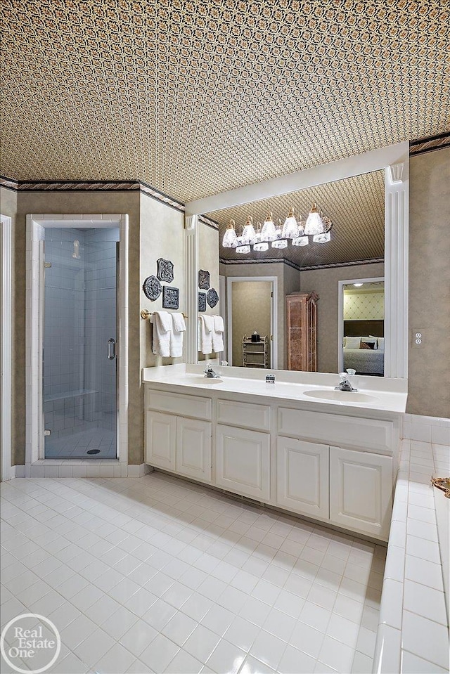 ensuite bathroom featuring ensuite bathroom, double vanity, a sink, and tile patterned floors