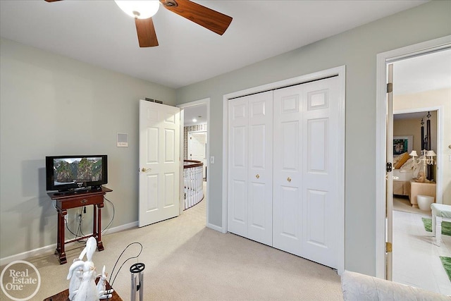 interior space with light carpet, ceiling fan, baseboards, and a closet