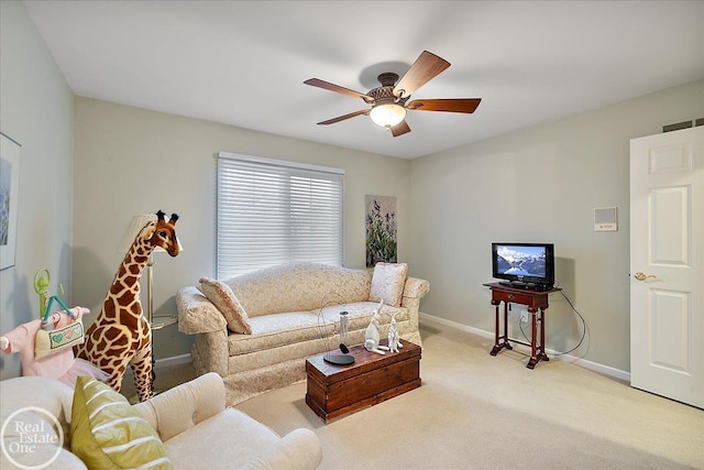 living area with baseboards, a ceiling fan, and light colored carpet