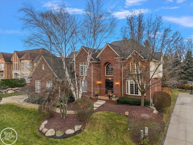 view of front facade with a front lawn and brick siding