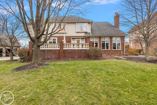 back of property featuring brick siding, a lawn, and a chimney