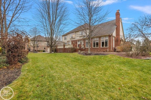 exterior space with brick siding, a yard, and a chimney