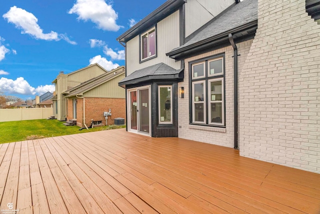 wooden terrace featuring central AC unit and a lawn