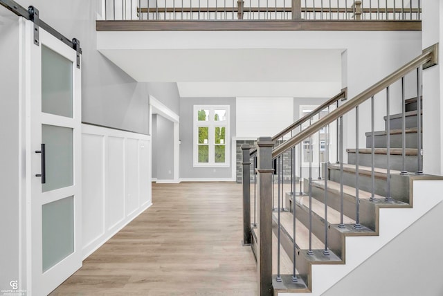 foyer entrance featuring a barn door and light hardwood / wood-style flooring