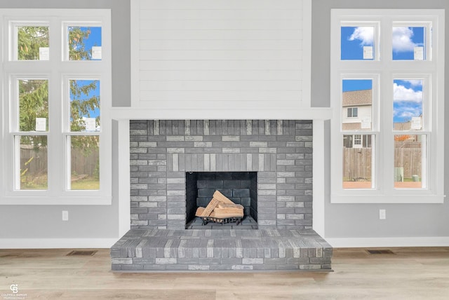 details featuring hardwood / wood-style flooring and a brick fireplace