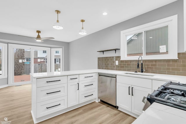 kitchen featuring stainless steel dishwasher, decorative light fixtures, white cabinets, and sink