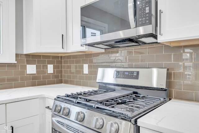 kitchen with tasteful backsplash, white cabinetry, and stainless steel appliances