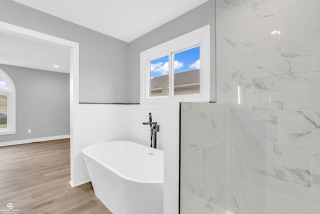 bathroom with a washtub and hardwood / wood-style floors