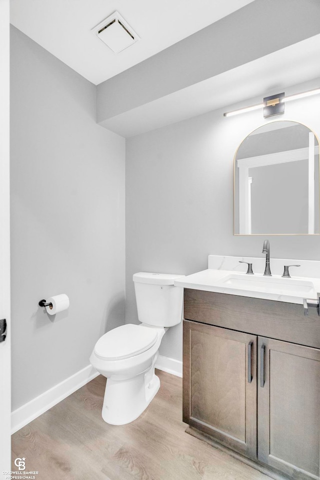 bathroom with vanity, hardwood / wood-style flooring, and toilet