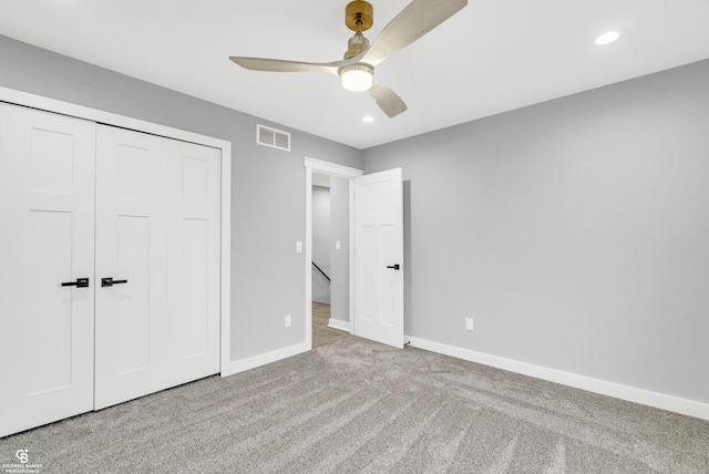 unfurnished bedroom with ceiling fan, a closet, and light colored carpet