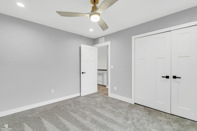 unfurnished bedroom featuring ceiling fan, a closet, and light carpet