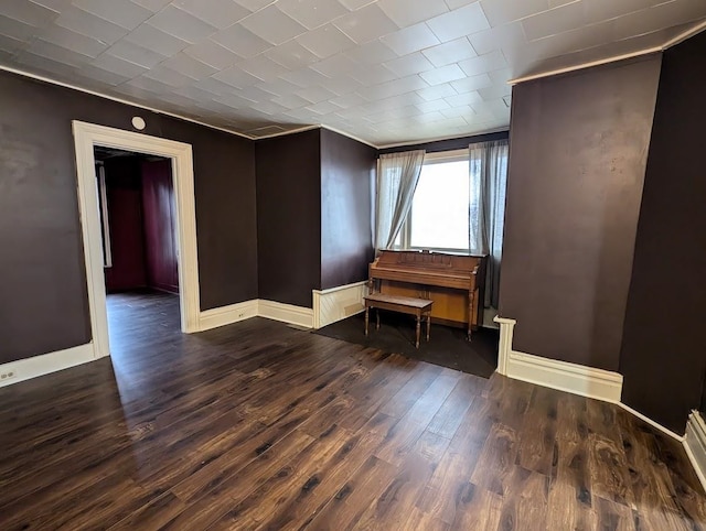 empty room with dark hardwood / wood-style flooring and ornamental molding