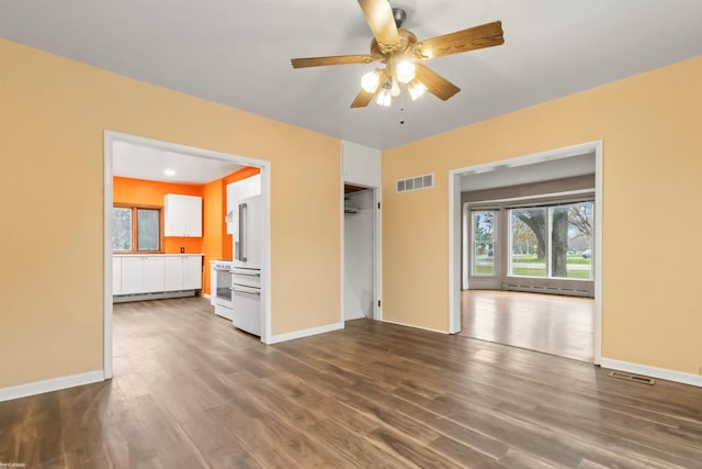 interior space featuring baseboard heating, ceiling fan, and hardwood / wood-style flooring