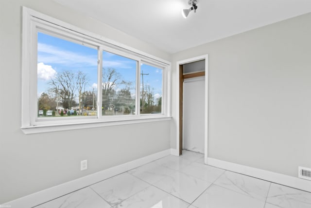 unfurnished bedroom featuring multiple windows and a closet