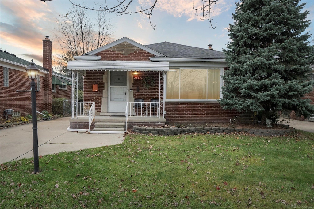 bungalow-style home with a lawn