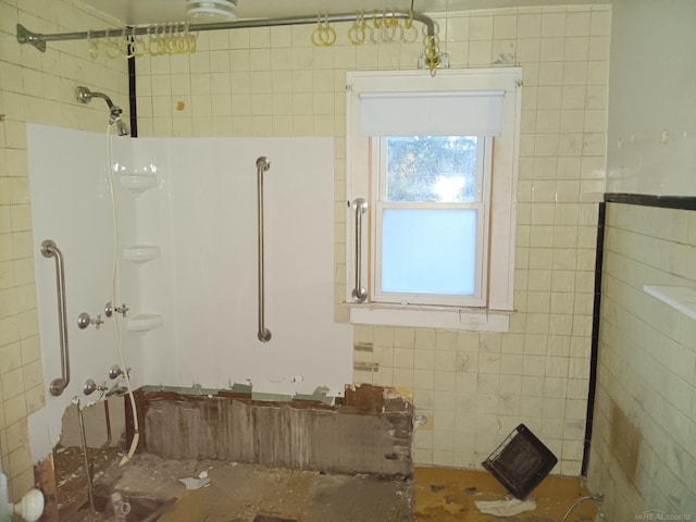 bathroom featuring a tile shower and tile walls