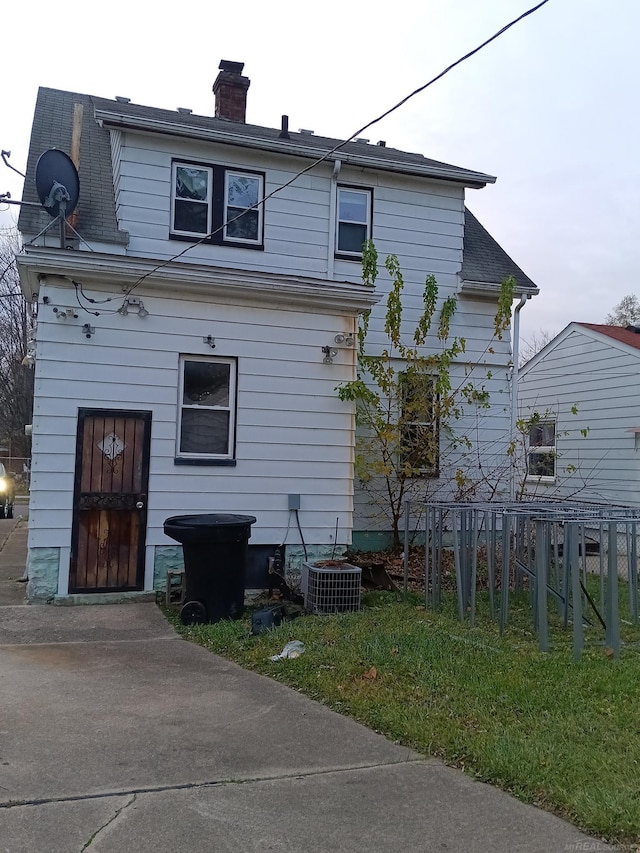 rear view of house featuring central air condition unit