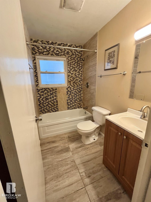 full bathroom featuring vanity, tiled shower / bath combo, and toilet